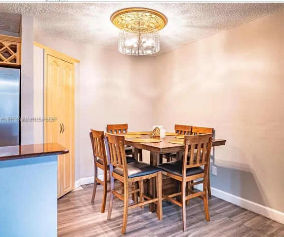 a view of a dining room with furniture a chandelier and wooden floor