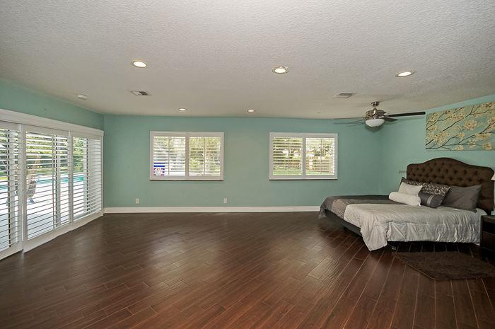 13387 Barwick Road Delray Beach, FL 33445 - Photo 13 of 28 a spacious bedroom with a bed and wooden floor
