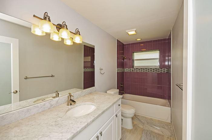 13387 Barwick Road Delray Beach, FL 33445 - Photo 19 of 28 a bathroom with a granite countertop sink a toilet and shower