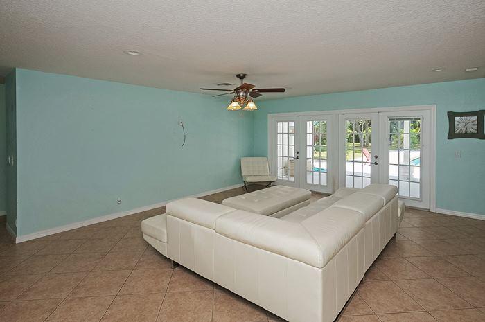 13387 Barwick Road Delray Beach, FL 33445 - Photo 4 of 28 a bedroom with a bed and a chandelier