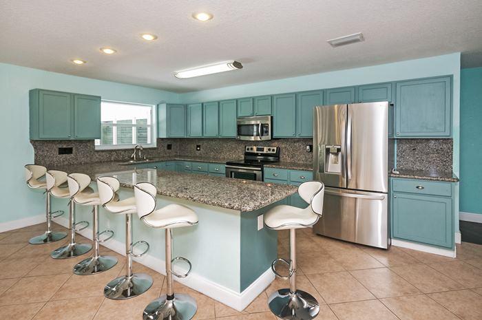 13387 Barwick Road Delray Beach, FL 33445 - Photo 8 of 28 a kitchen with stainless steel appliances granite countertop a refrigerator and a stove