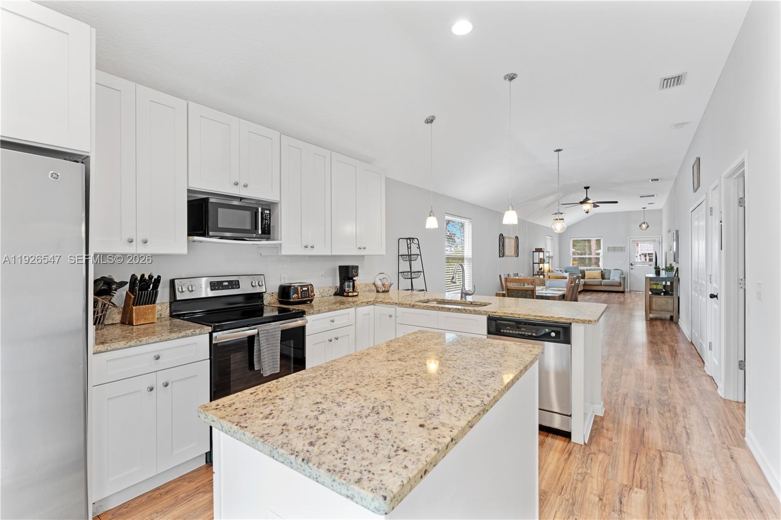 2 Poinciana Cove Road St. Augustine, FL 32084 - Photo 1 of 43 a kitchen with stainless steel appliances granite countertop a stove top oven a sink dishwasher and a refrigerator with wooden floor