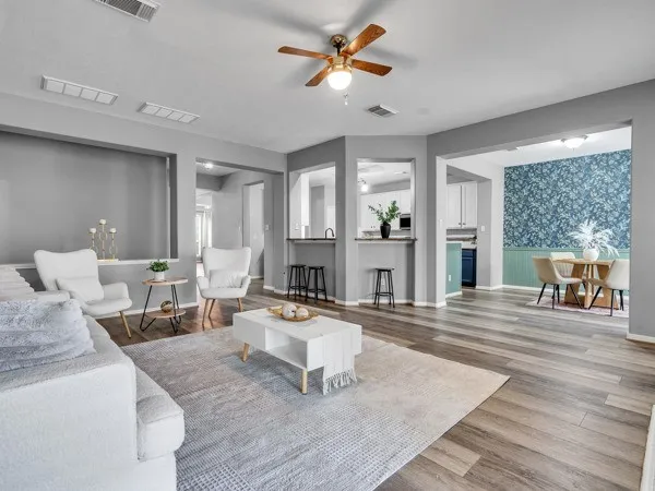 a living room with couches and a view of kitchen