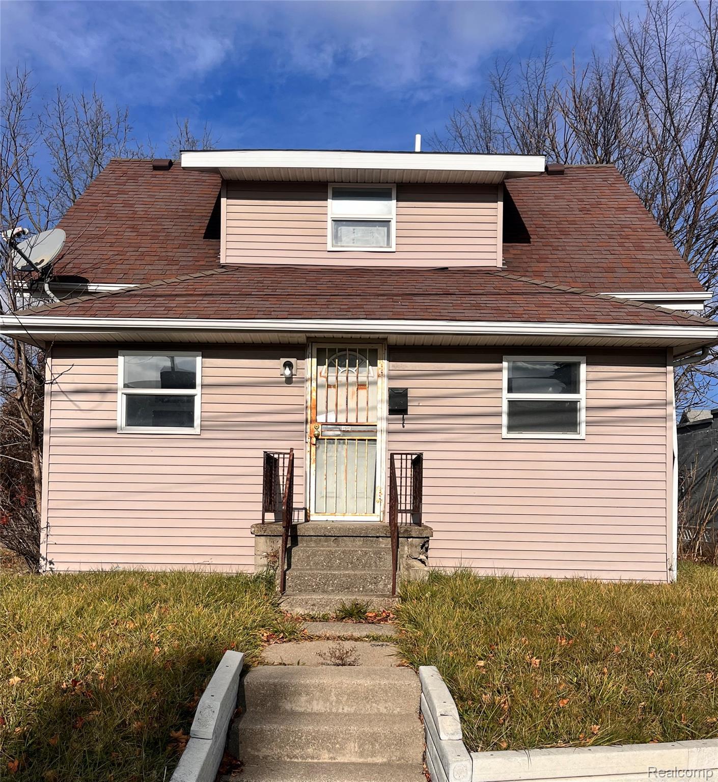 Bungalow featuring a front lawn and a shingled roof