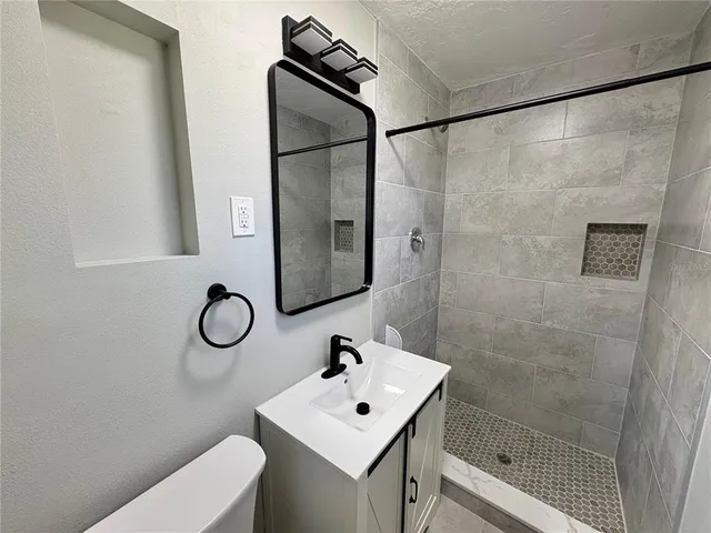 a bathroom with a sink mirror toilet and shower