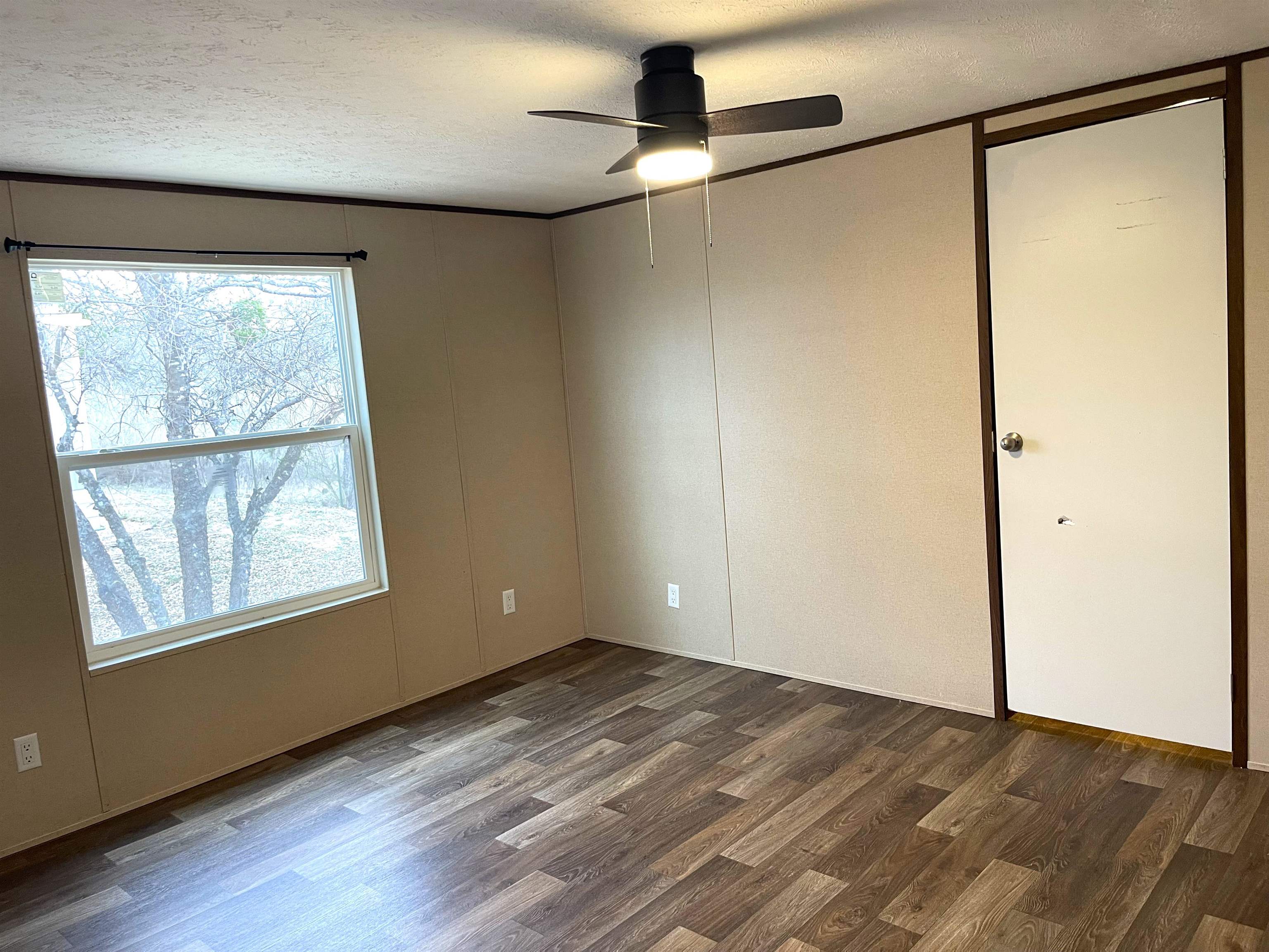 810 East Collins Street Llano, TX 78643 - Photo 11 of 14 a view of an empty room with a window and wooden floor