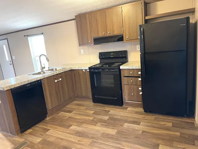 a kitchen with stainless steel appliances granite countertop a refrigerator stove and sink
