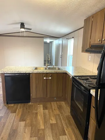 a kitchen with stainless steel appliances granite countertop a stove a sink and a microwave