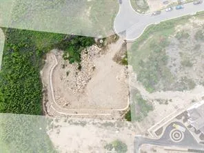 a view of a dry yard with wooden fence