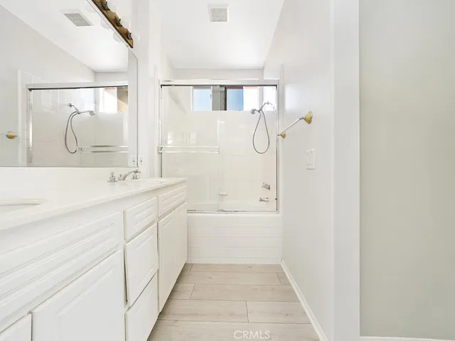 a bathroom with a double vanity sink mirror and shower