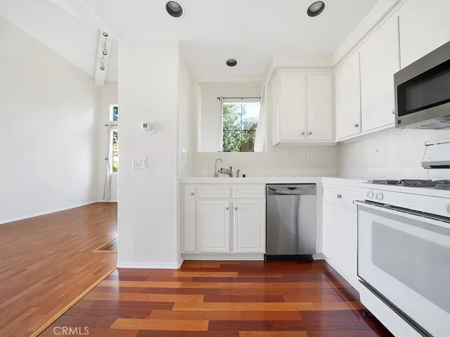 a kitchen with white cabinets and white appliances