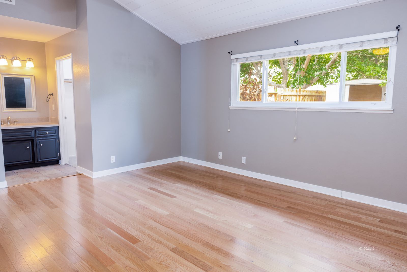 921 North Sierra View Street Ridgecrest, CA 93555 - Photo 14 of 27 a view of an empty room with wooden floor and a window