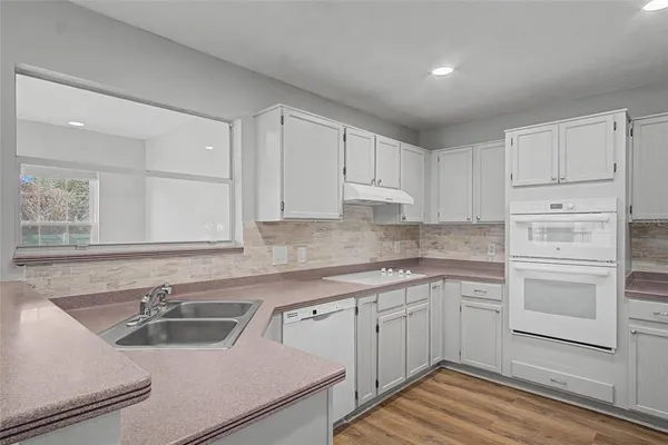 a kitchen with cabinets appliances a sink and a counter top