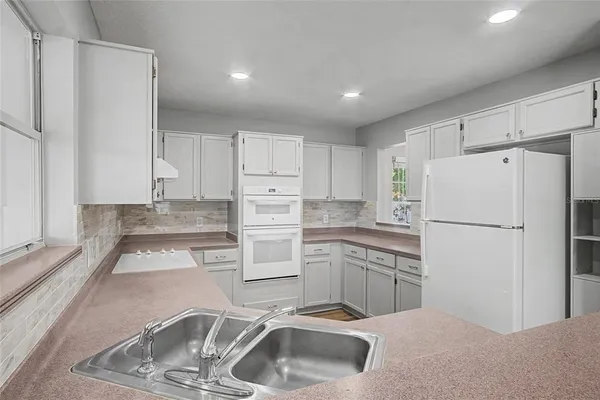 a kitchen with a refrigerator sink and cabinets