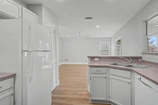 a bathroom with a granite countertop sink two mirror and shower