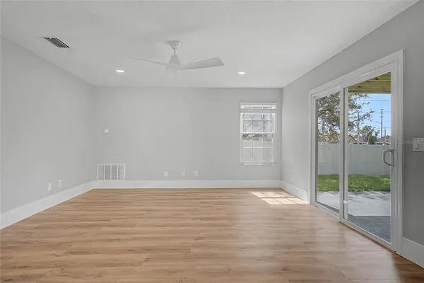 a view of an empty room with glass door and a window
