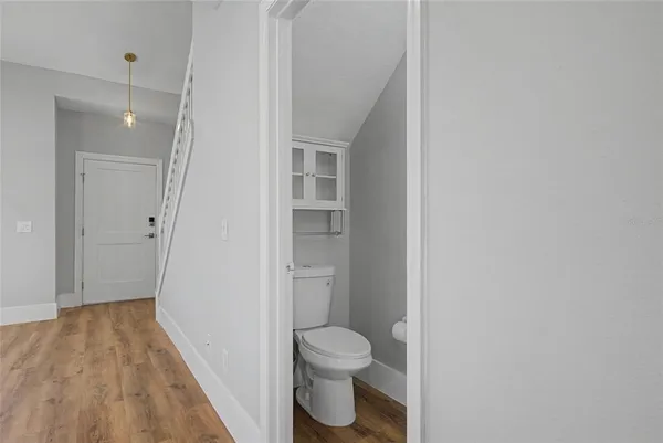 a bathroom with a toilet and a hardwood