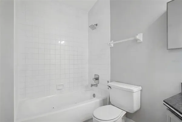 a white toilet sitting next to a bath tub