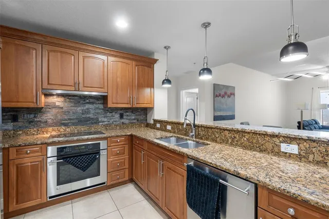 a kitchen with a sink a refrigerator and chairs