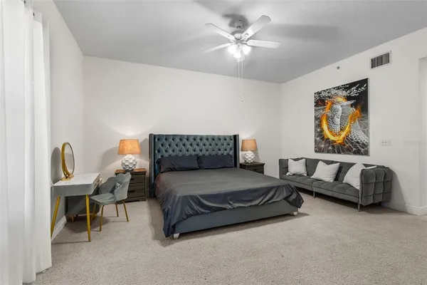 a spacious bedroom with a bed and a chandelier