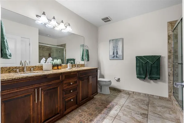 a spacious bedroom with a bed and a chandelier