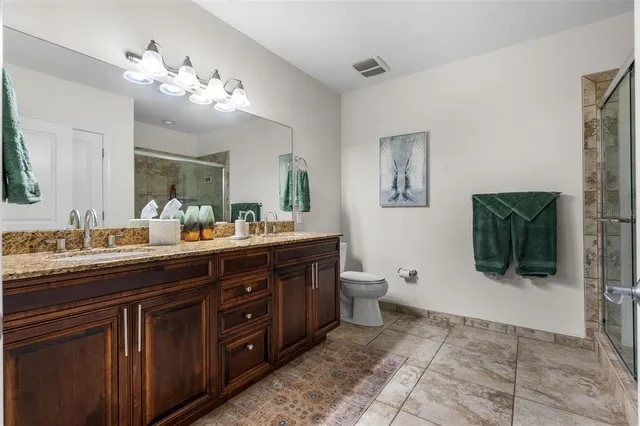 a spacious bedroom with a bed and a chandelier