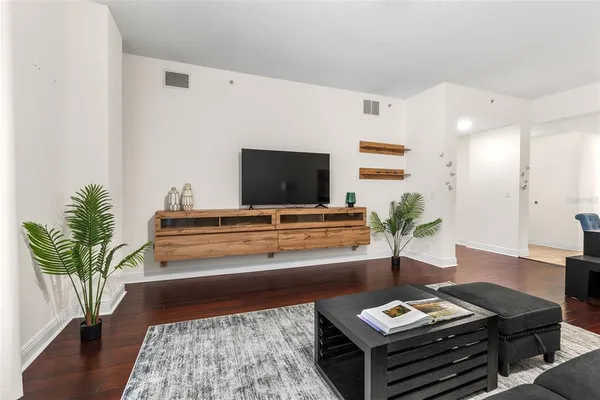 a living room with furniture a table and wooden floor