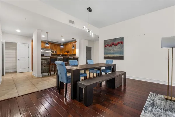 a kitchen with stainless steel appliances granite countertop a sink a stove a kitchen island with chairs and cabinets