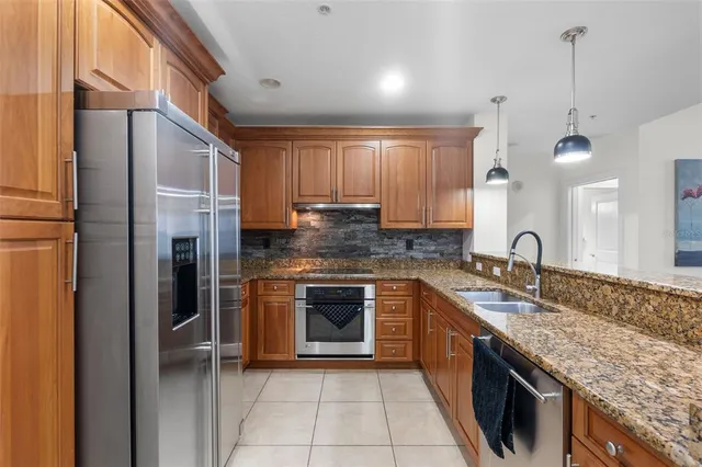 a kitchen with granite countertop stainless steel appliances sink stove and cabinets
