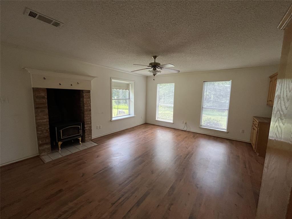 210 Vz County Road 2139 Canton, TX 75103 - Photo 11 of 18 an empty room with wooden floor fireplace and windows