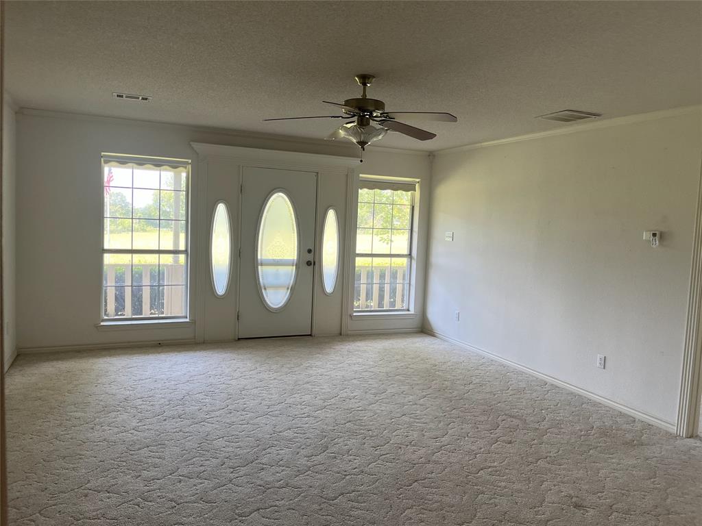 210 Vz County Road 2139 Canton, TX 75103 - Photo 10 of 18 an empty room with chandelier fan and windows