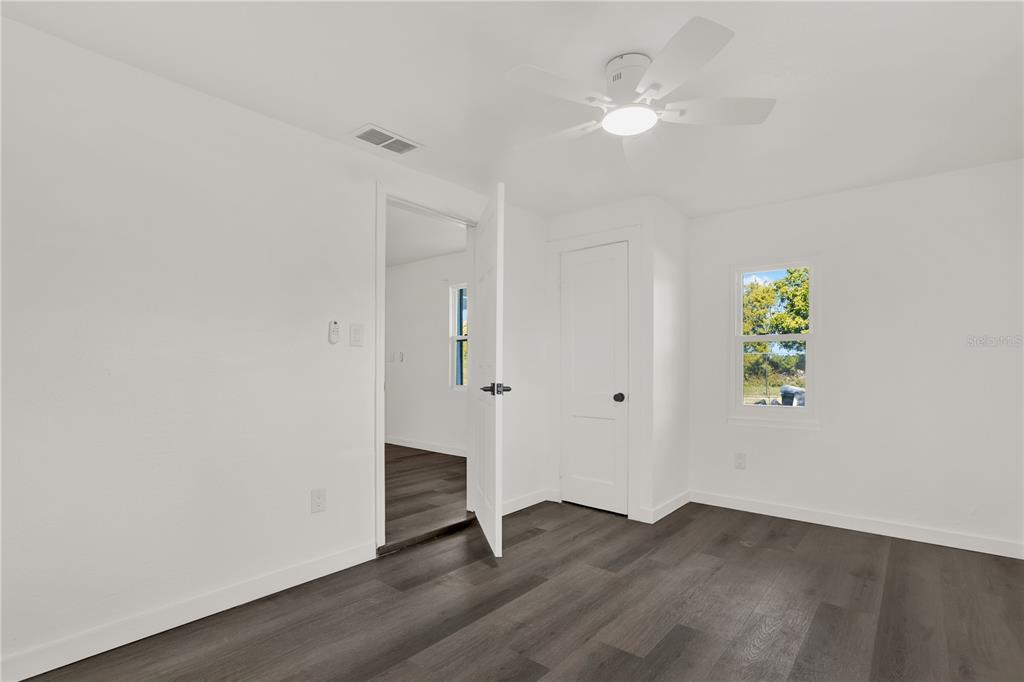 1955 Gilbert Street Clearwater, FL 33765 - Photo 5 of 24 an empty room with wooden floor and a ceiling fan