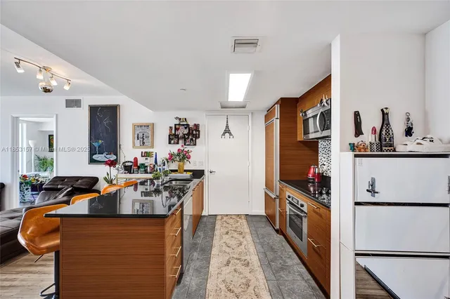 a kitchen with stainless steel appliances granite countertop a stove refrigerator and a dining table