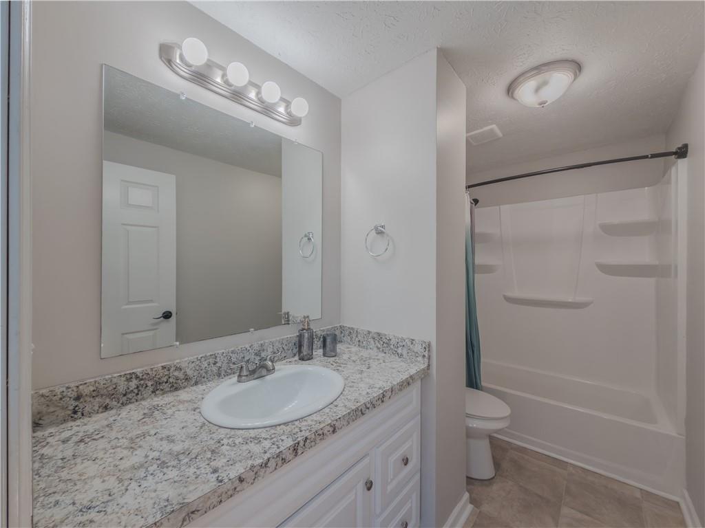 5728 Salem Road Lithonia, GA 30038 - Photo 19 of 35 a bathroom with a granite countertop sink toilet and shower