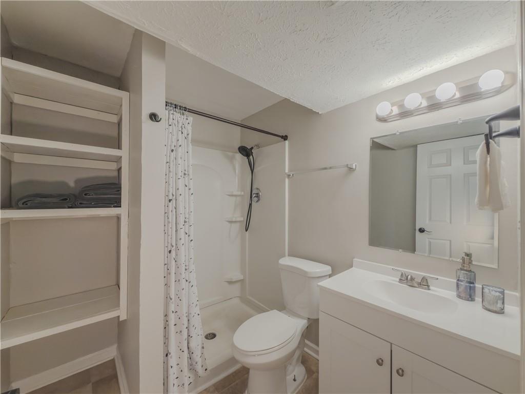 5728 Salem Road Lithonia, GA 30038 - Photo 25 of 35 a bathroom with a granite countertop sink toilet and shower