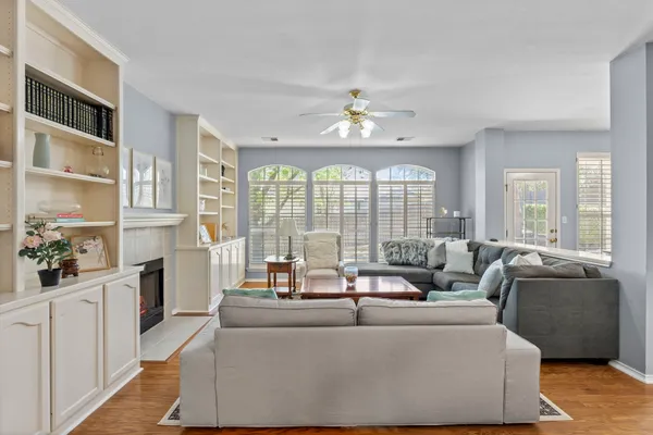 a living room with furniture kitchen view and a chandelier