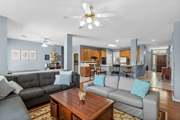 a kitchen with stainless steel appliances kitchen island granite countertop a table chairs and a refrigerator