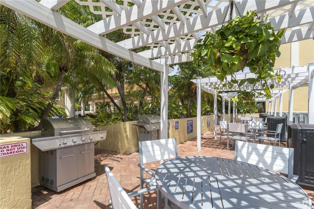 16900 North Bay Road, Unit 3514 Sunny Isles Beach, FL 33160 - Photo 22 of 27 a view of a patio with table and chairs potted plants and large tree