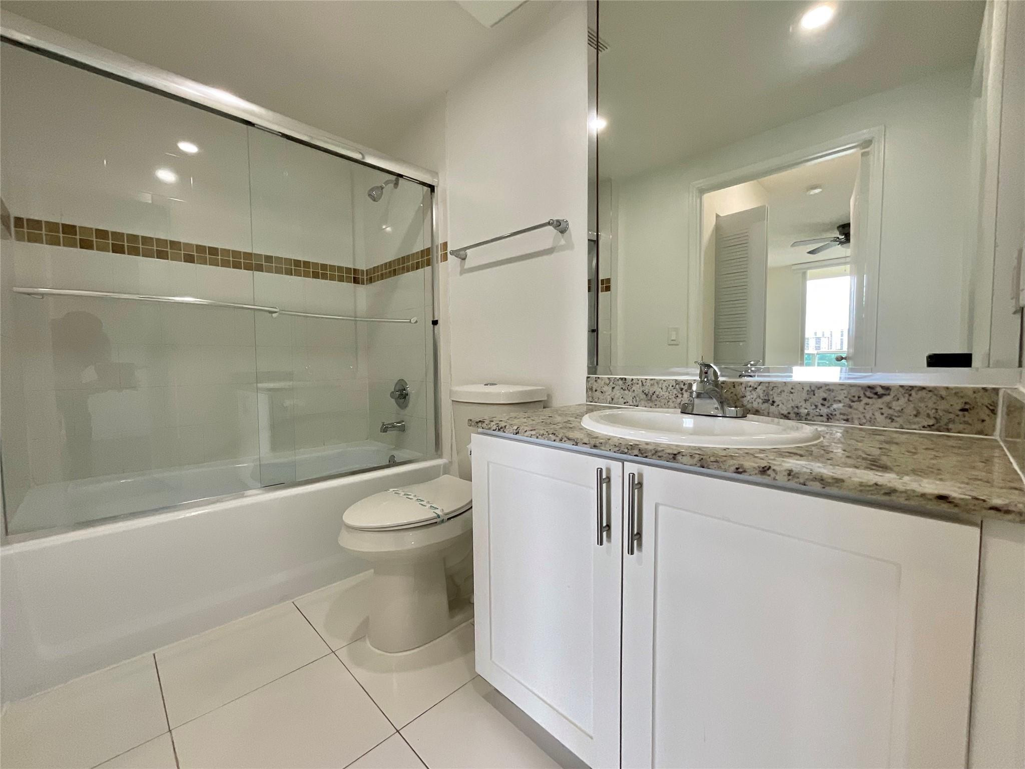 16900 North Bay Road, Unit 3514 Sunny Isles Beach, FL 33160 - Photo 3 of 27 a bathroom with a granite countertop sink a toilet and shower