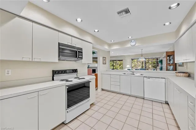 a kitchen with white cabinets appliances and sink
