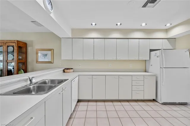 a kitchen with white cabinets sink and white appliances
