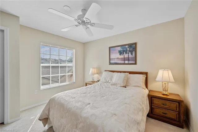 a bedroom with a bed and a lamp on dresser
