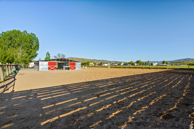 681 Island Road Morgan, UT 84050 - Photo 28 of 49 Expansive outdoor riding arena featuring a perimeter fence and a metal-clad barn with red sliding doors