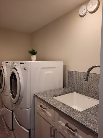 1106 Busse Road Mount Prospect, IL 60056 - Photo 22 of 27 a bathroom with a granite countertop sink and a washing machine