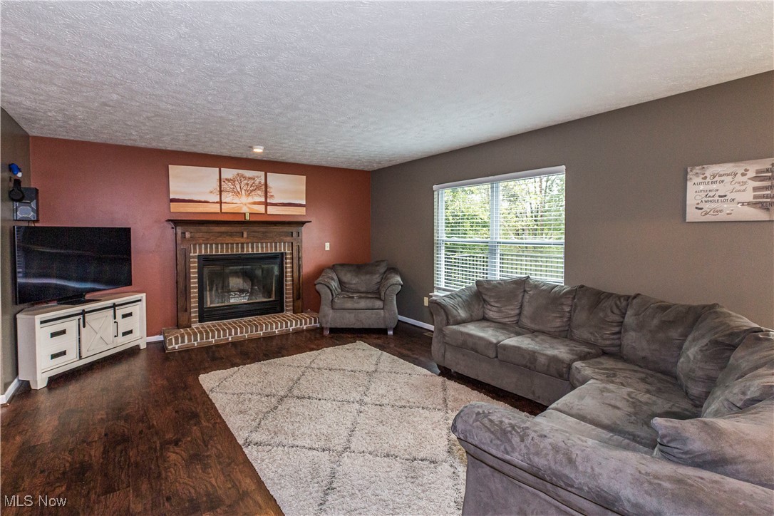16727 Galehouse Road Doylestown, OH 44230 - Photo 13 of 38 Living room featuring a textured ceiling, a fireplace, and dark wood-type flooring