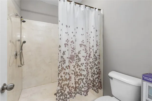 a white toilet sitting next to a shower curtain