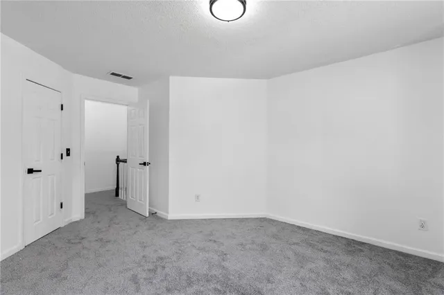 a spacious bedroom with a bed and a chandelier