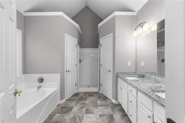 a bathroom with a granite countertop sink two mirror and a shower