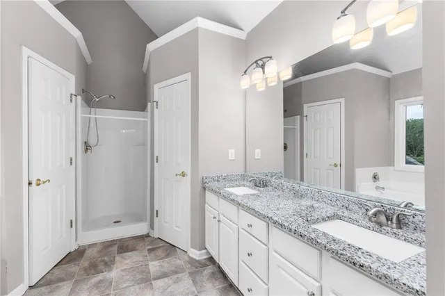 a spacious bathroom with a granite countertop sink a mirror and shower