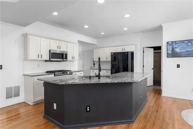 a kitchen with stainless steel appliances granite countertop a sink stove and refrigerator